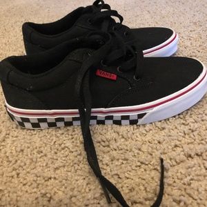 Black Vans with checkerboard pattern around bottom